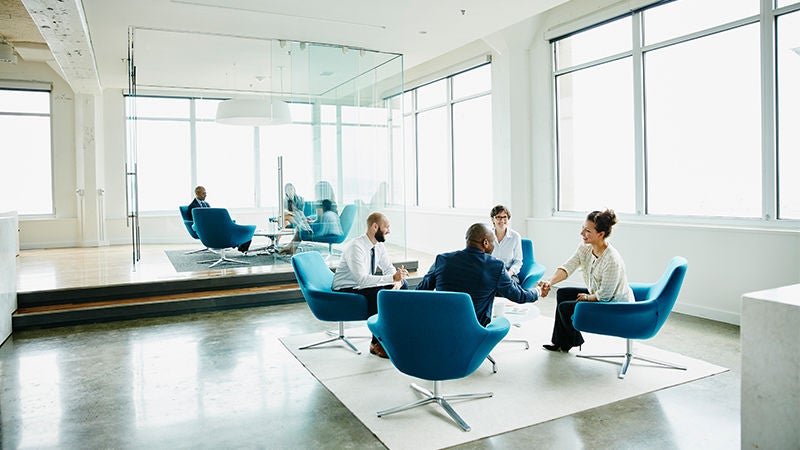 People in business meeting sitting in blue chairs