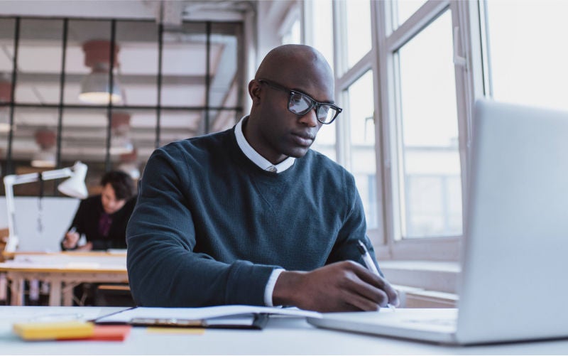 Man with glasses using laptop