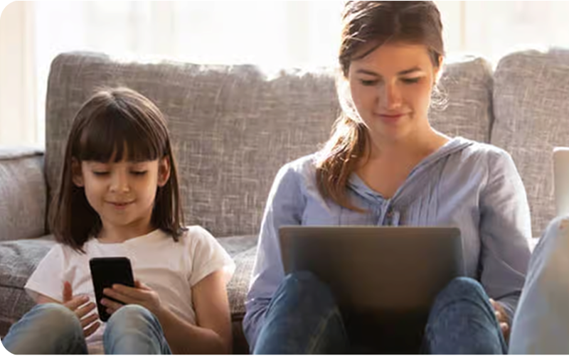 Mother and daughter using digital devices