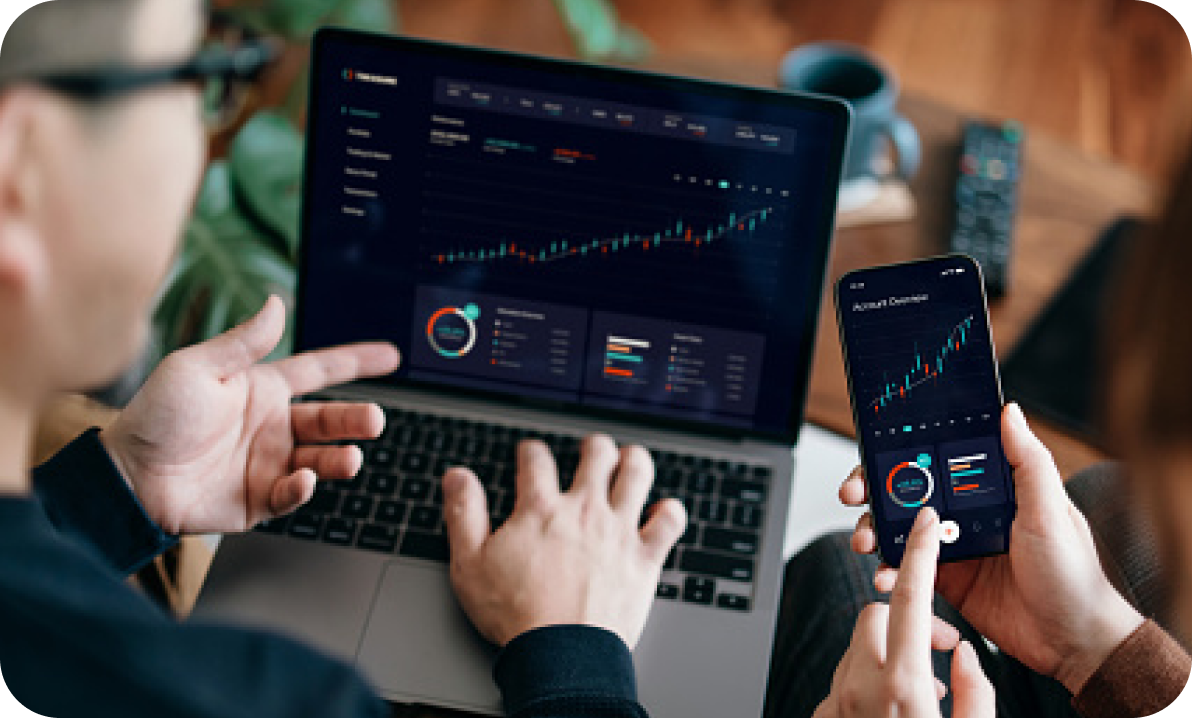 Financial charts on laptop and phone
