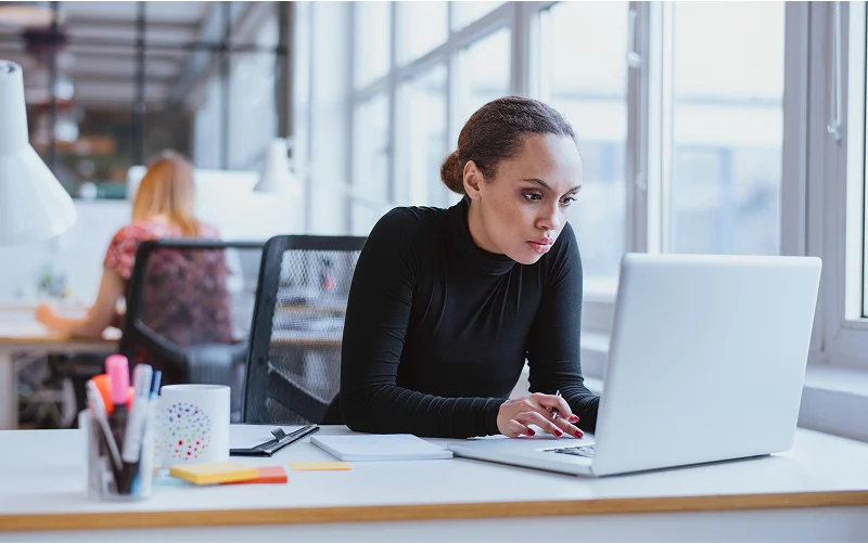 Woman in black shirt working on laptop
