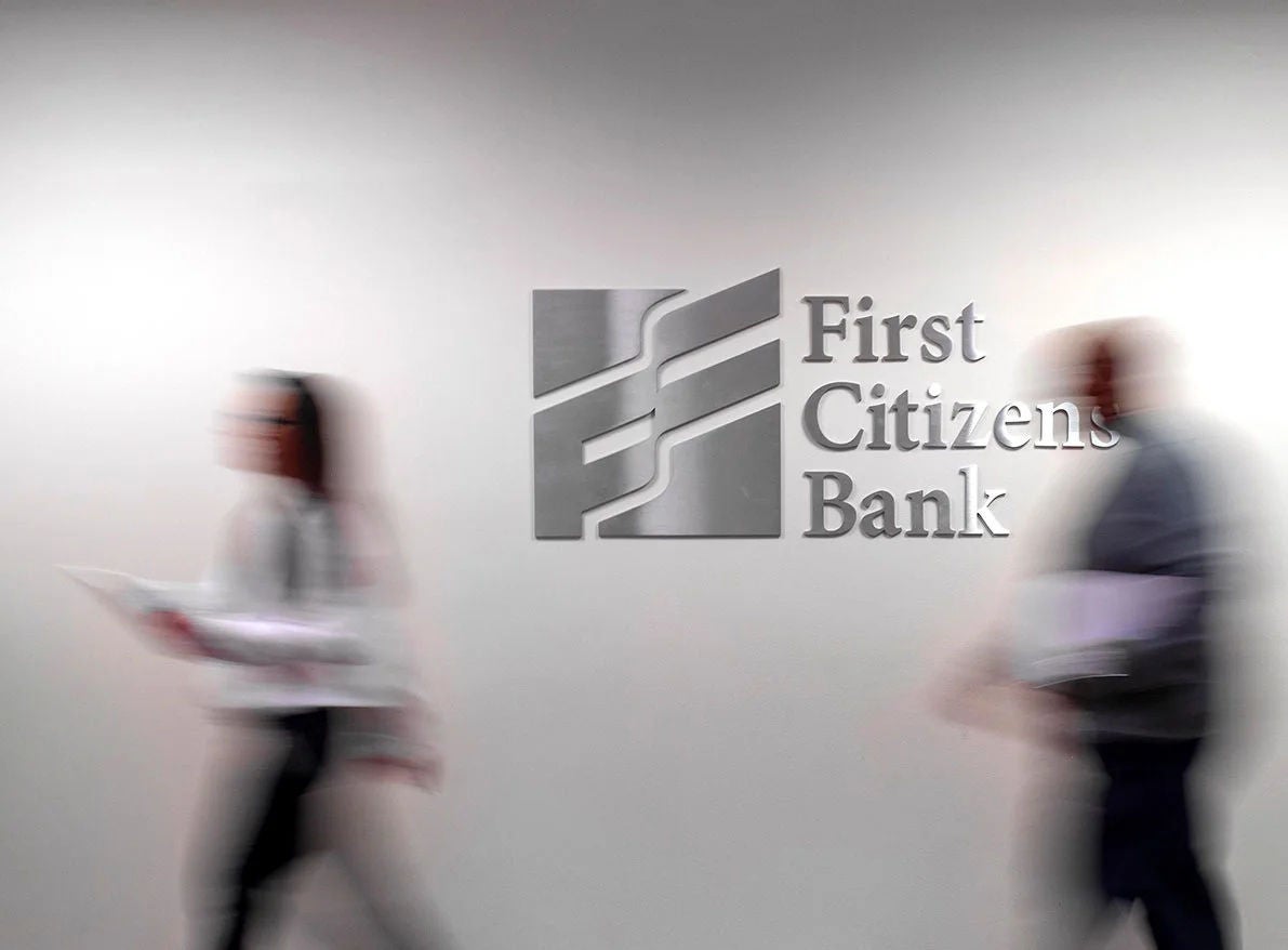 Workers in front of First Citizens Bank logo